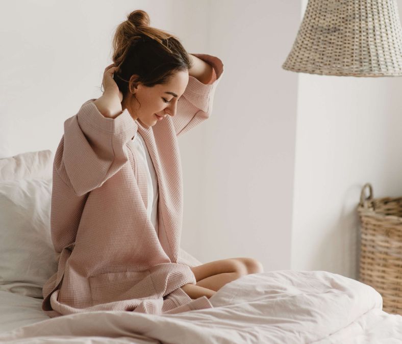 Girl in bed putting up her hair