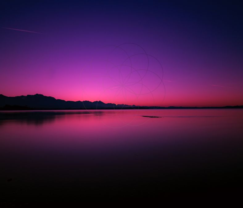 Sunset over a lake with mountains in background